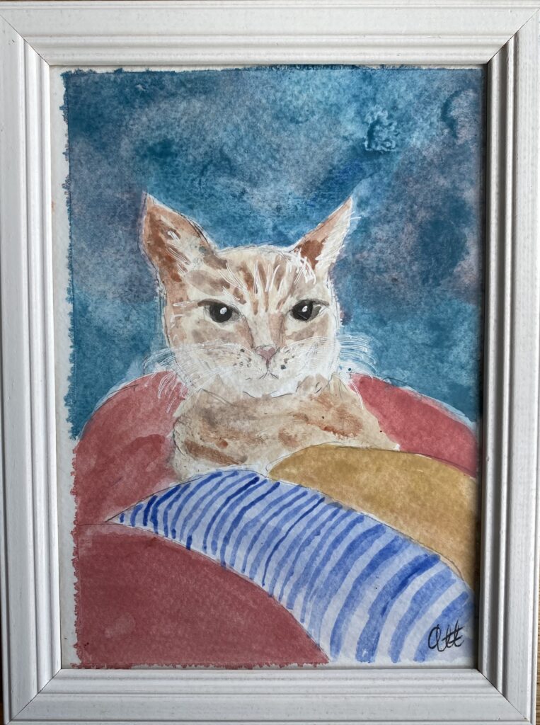 Akvarell som visar katt som ligger i en hög med tvätt